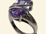 une image d'un gros plan d'une bague avec une pierre violette