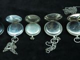many different types of silver jewelry on a black surface