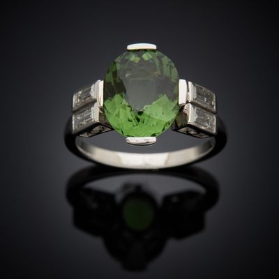 a close up of a green tourmaline and diamond ring