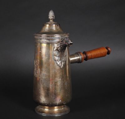 une cafetière ancienne en argent avec une poignée en bois