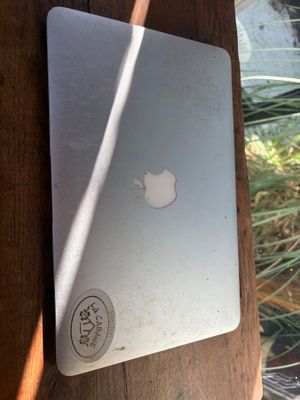 a white apple laptop sitting on a wooden table
