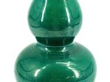 a green vase that is sitting on a white surface