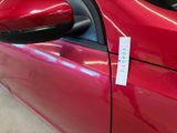 a close up of a red car with a sticker on it