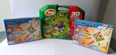trois jouets d'enfants sont posés sur une table blanche, les uns à côté des autres