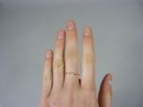 a woman ' s hand with a gold ring on it