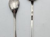 two spoons and a spoon on a white surface