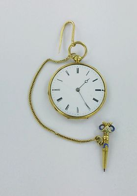 une petite montre de poche en or, attachée à une chaîne