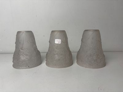 three cement vases sitting on a shelf next to each other