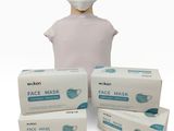 trois boîtes de masques faciaux et une tête de mannequin sur fond blanc