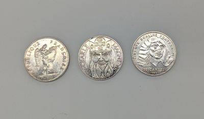 trois types différents de pièces d'argent sur une surface blanche