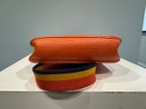 two pieces of orange and yellow purse sitting on top of a white table