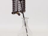 un vase en verre contenant une fleur en perles