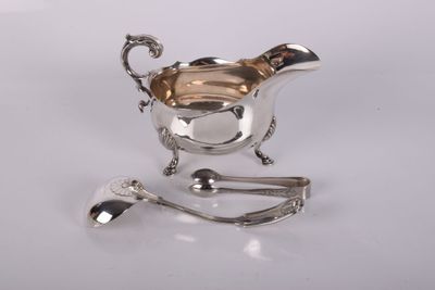 crémier plaqué argent avec cuillère et repose-cuillère, posé sur un support blanc