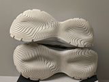 the soles of a pair of white sneakers on a black and white surface