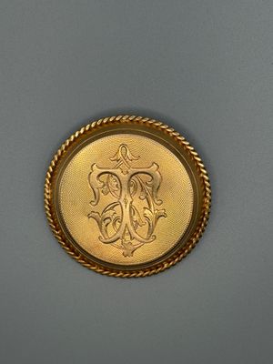 une image représentant une pièce d'or sur laquelle figure un monogramme