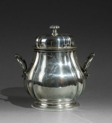 une théière en argent avec un couvercle, posée sur une table
