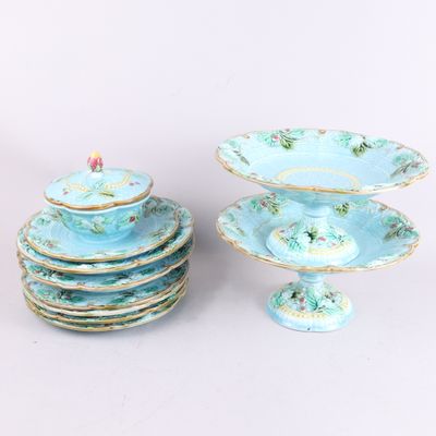 une pile d'assiettes et un plat à gâteau sur lequel est posée une bougie