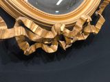 a gold frame with a clock on it on a black table