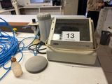 a computer monitor sitting on top of a counter next to a speaker