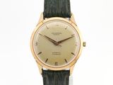 une photo d'une montre-bracelet en or avec un bracelet en cuir vert