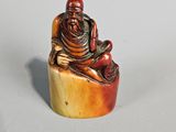 an image of a small figurine of a man sitting on a rock