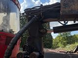 a tractor that is parked next to a red bus