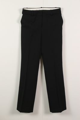 un pantalon noir accroché à un mur blanc