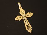 a gold cross on a black surface with a black background