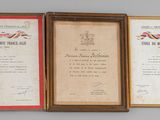 three framed pictures of military medals on display on a wall