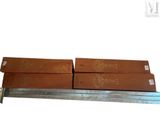 two brown boxes sitting on top of a metal shelf next to a ruler
