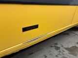 a close up of a yellow bus parked on the side of the road