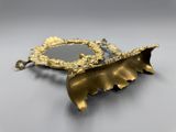 un gros plan d'un miroir en forme de feuille d'or posé sur une table
