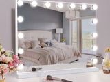 a white vanity with a mirror and lights on it
