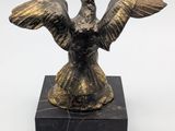 a bronze statue of a bird on a marble base