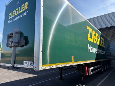 un semi-remorque garé devant un immeuble