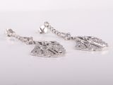 a pair of silver leaf earrings on a white background