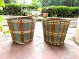 two planters that are sitting on a brick floor