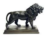 bronze statue of a lion on a marble base on a white background