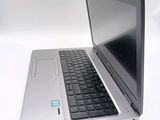 a silver laptop with a black keyboard on a white surface