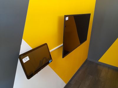 une télévision fixée au mur dans un coin de la pièce