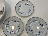 four plates and a bowl sitting on a table