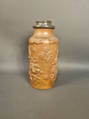 a yellow vase with a silver lid sitting on a table
