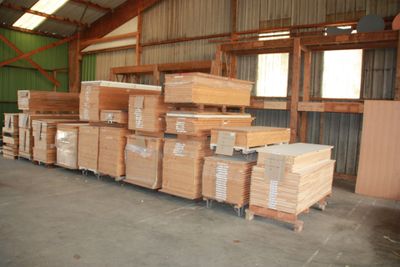 many stacks of wood in a warehouse with a lot of pallets