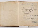 an old book with writing on it sitting on top of a table