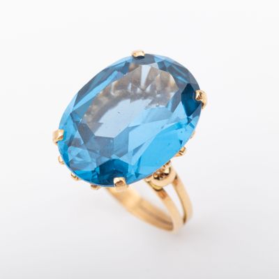a close up of a blue topaz ring on a white background
