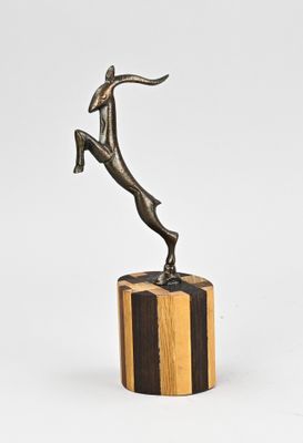 bronze sculpture of a woman leaping over a wooden block