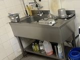 une cuisine équipée d'un évier, d'une cuisinière et d'une poubelle