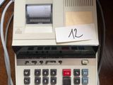 a calculator sitting on top of a table with a note taped to it