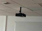 un petit projecteur suspendu au plafond dans une salle de classe