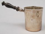 a silver cup with a handle on a white surface